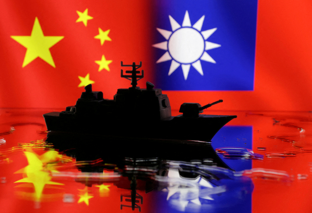 A Navy miniature is seen in front of displayed Chinese and Taiwanese flags (Reuters/Yonhap)