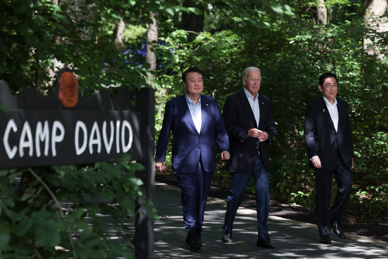 South Korean President Yoon Suk Yeol, US President Joe Biden and Japanese Prime Minister Fumio Kishida enter the venue for their summit talks held at the Camp David presidential retreat in Maryland, Friday. (Yonhap)