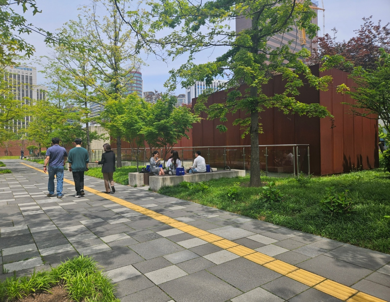 People walk and sit to chat at Seosomun Historic Park during a lunch time on May 10. (Park Yuna/The Korea Herald)
