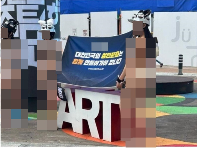 Women holding a banner wear bikinis on a street in Daegu. (Screenshot capture from an online community)