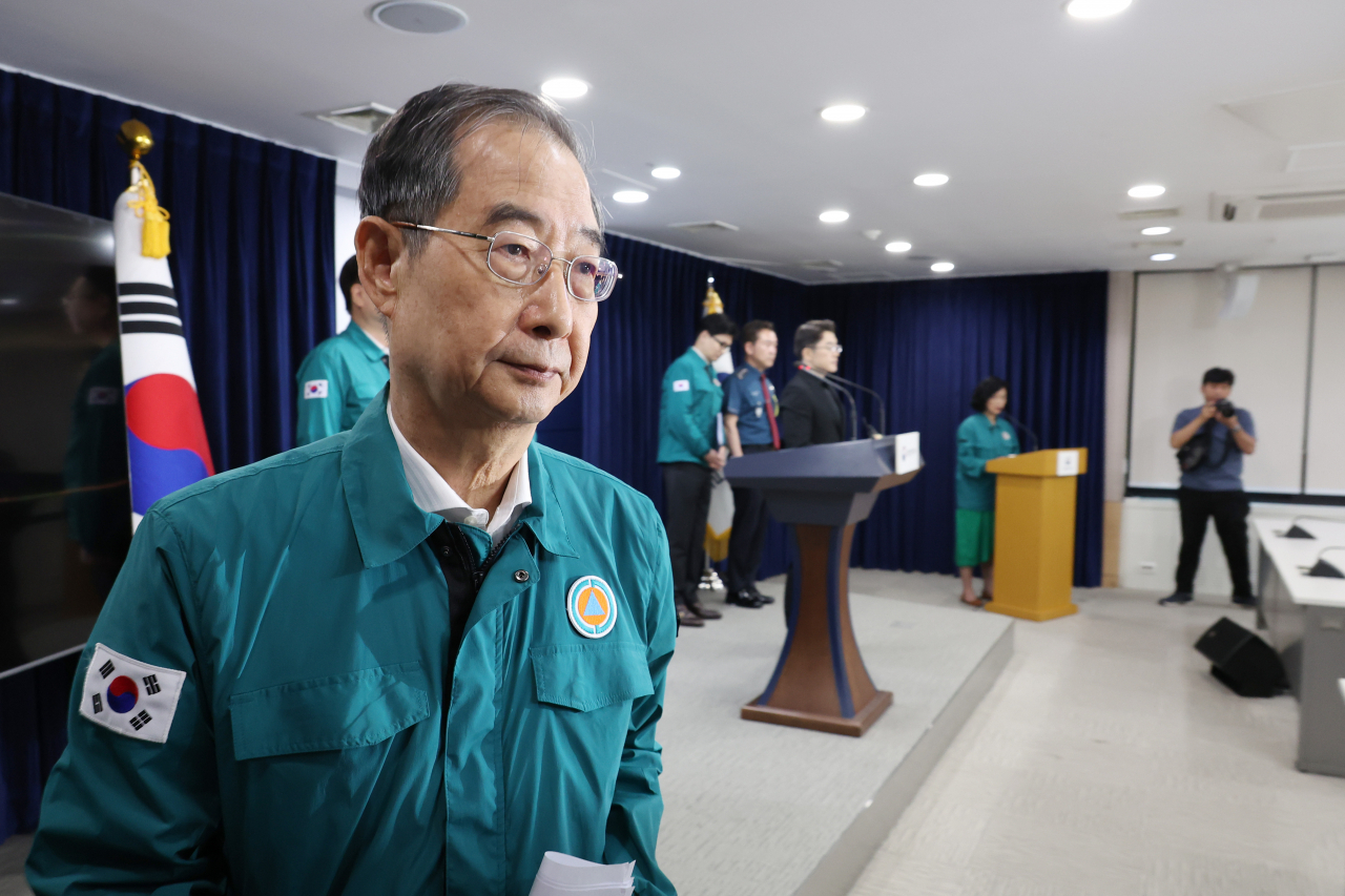 Prime Minister Han Duck-soo walks out of the briefing room after the speech in the Government Complex Seoul Wednesday. (Yonhap)