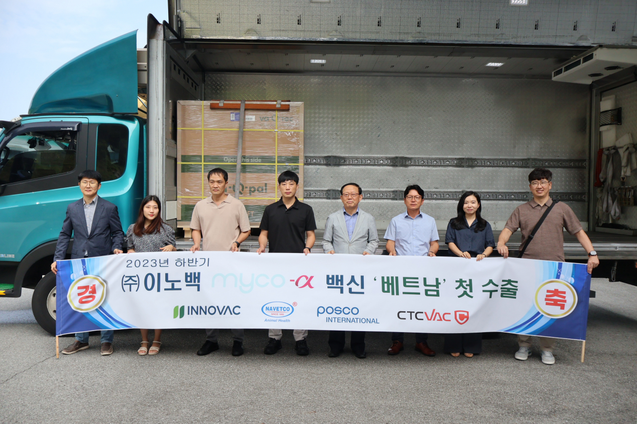 Posco International and Innovac officials, including Innovac adviser Kim Bong-cheol (fourth from right), hold a placard celebrating the first overseas export of an animal vaccine. (Posco International)