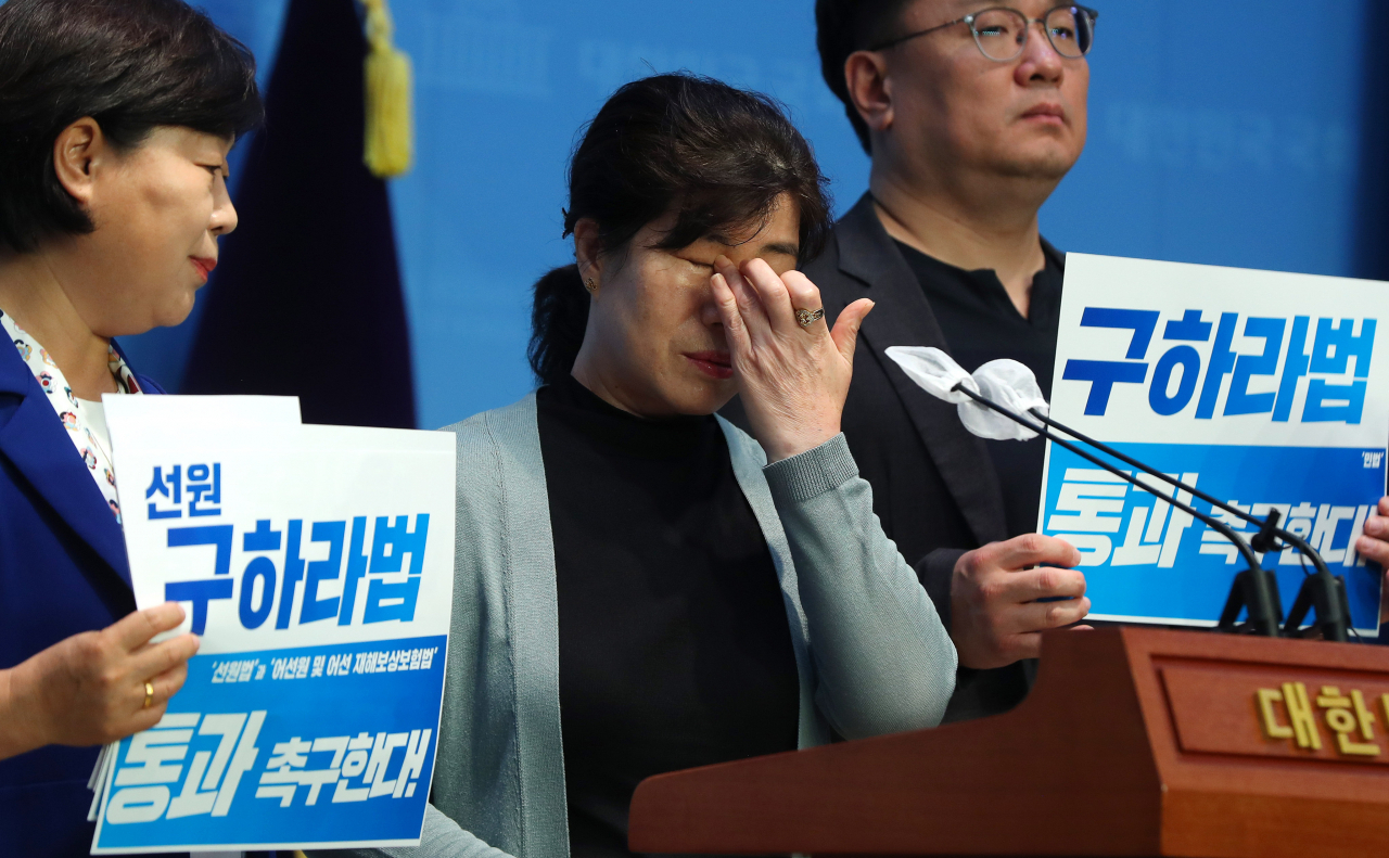 Kim Jong-seon, the older sister of the late Kim Jong-an, sheds a tear during a press conference at the National Assembly on Aug. 9. (Newsis)