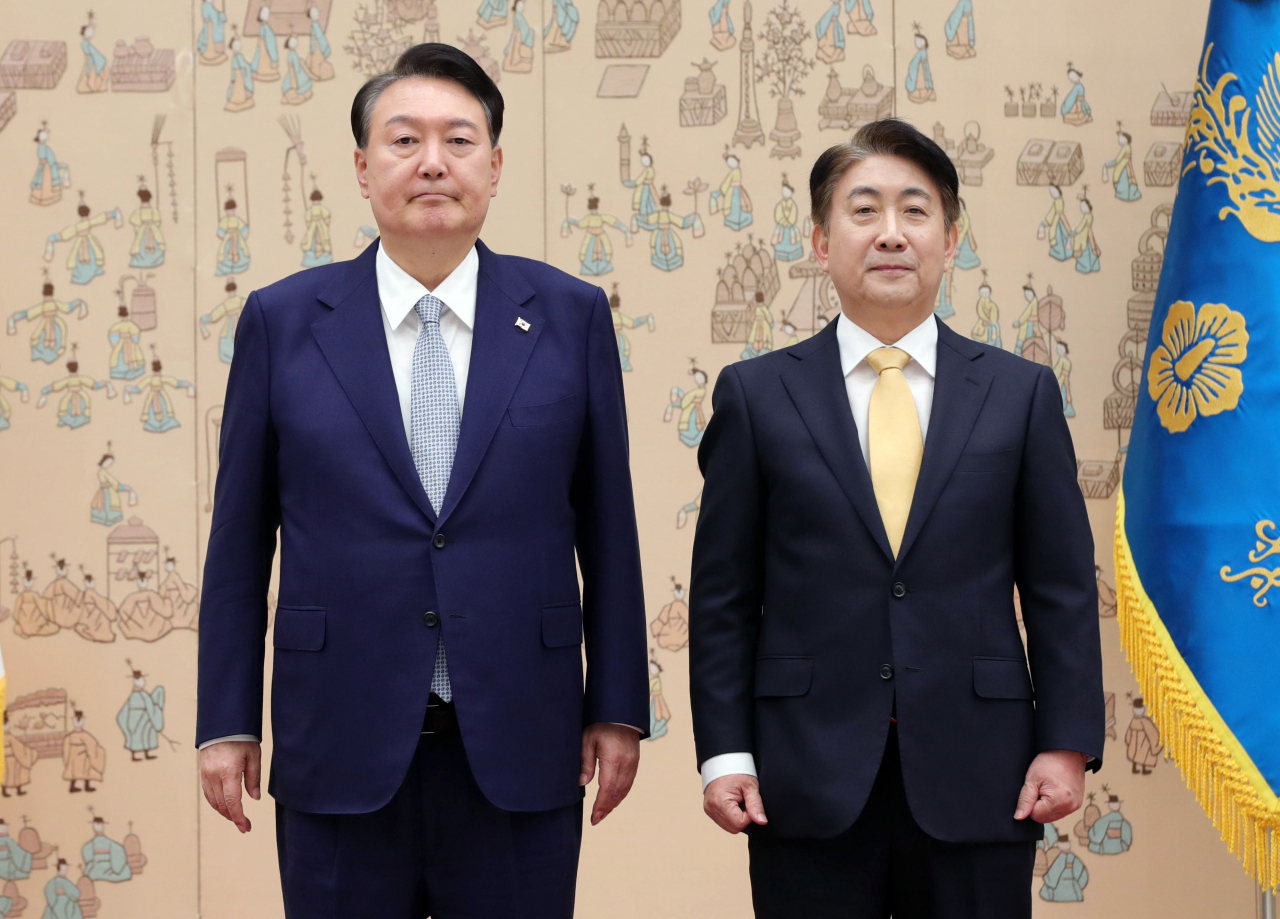 President Yoon Suk Yeol (left) and the Korea Communications Commission's new chief Lee Dong-kwan pose for a photo after Yoon conferred a letter of appointment at the presidential office in Yongsan-gu, Seoul, Friday. (Joint Press Corps)