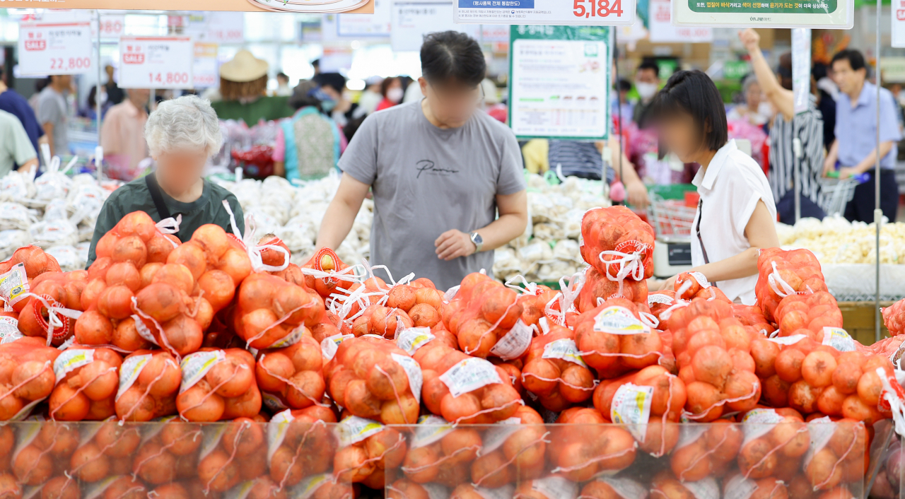 People shop for groceries at a supermarket in Seoul on Sunday. The prices of vegetables and fruits have been on the rise following heavy rains and heat waves. (Yonhap)
