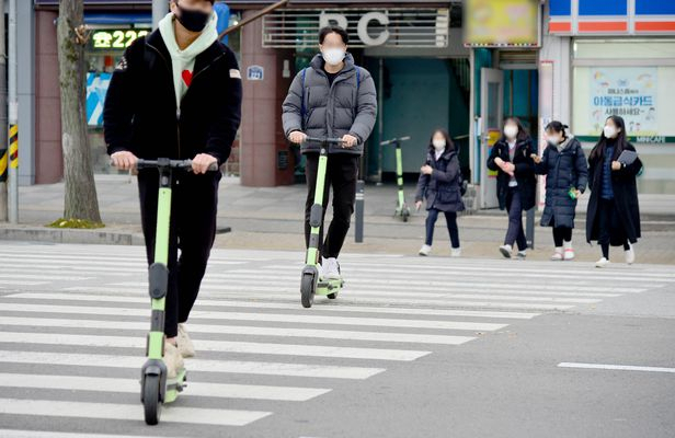 Two e-scooter riders pass through crosswalk in Seoul. (Newsis)
