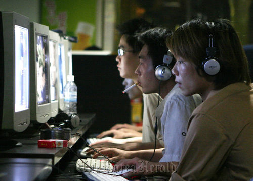 This undated photo shows a group of people engrossed in computer activities at a PC bang. (Herald DB)