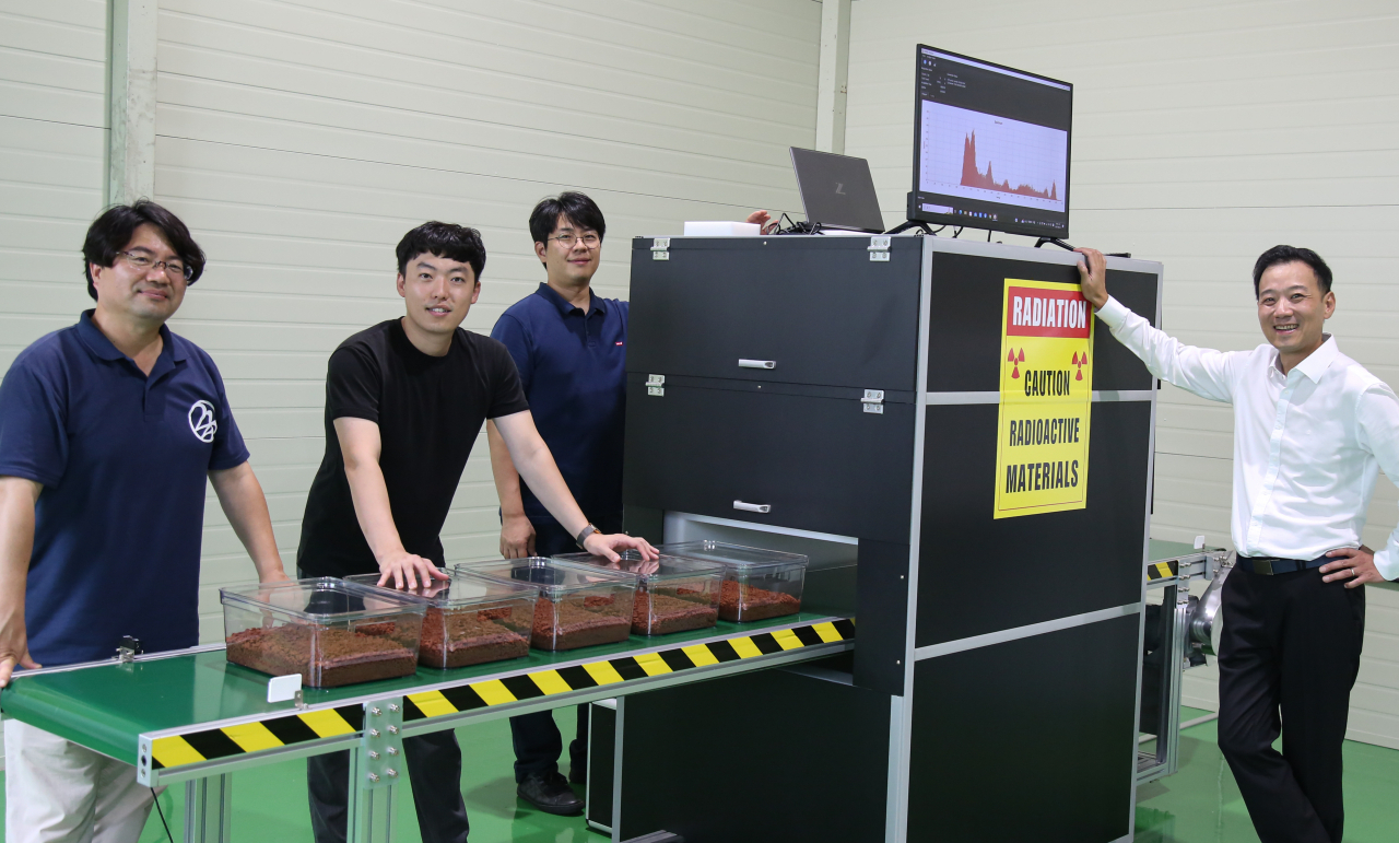 The 3I Solutions team poses for a picture next to the newly developed Industrial Neutron Composition Analyzer. (Hyundai Steel)