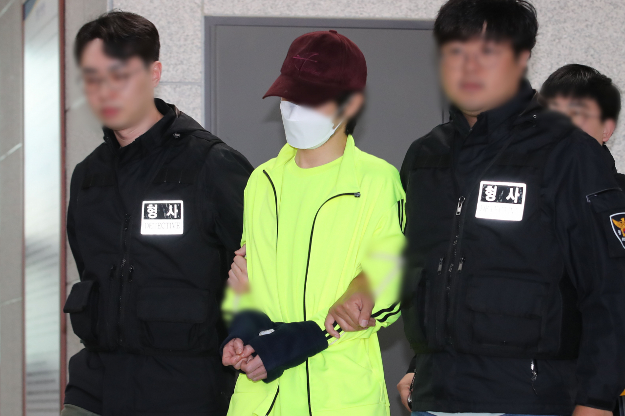 This photo shows a 33-year-old man surnamed Kim (center) on May 28 en route to a prosecution as the police then sought revenge murder charges. (Newsis)