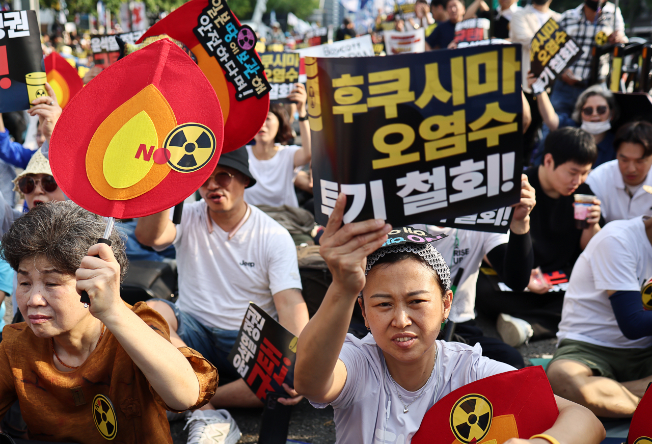 Protesters stage sit-ins last Saturday in downtown Seoul against Japan's release of contaminated water from the Fukushima plant. (Yonhap)