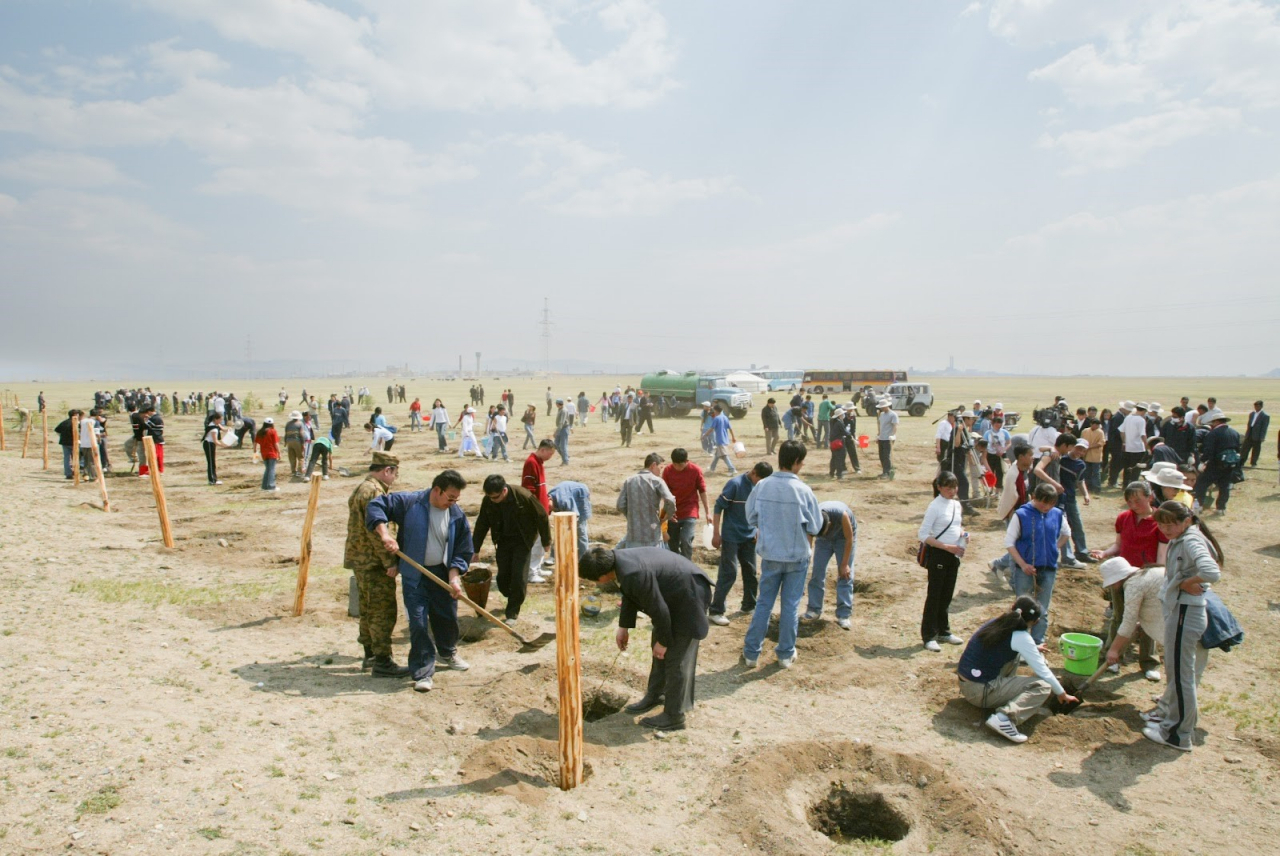 Korean Air employees and local residents are planting trees in the desert of Baganuur in May 2004, the first year of the planting project. (Korean Air)