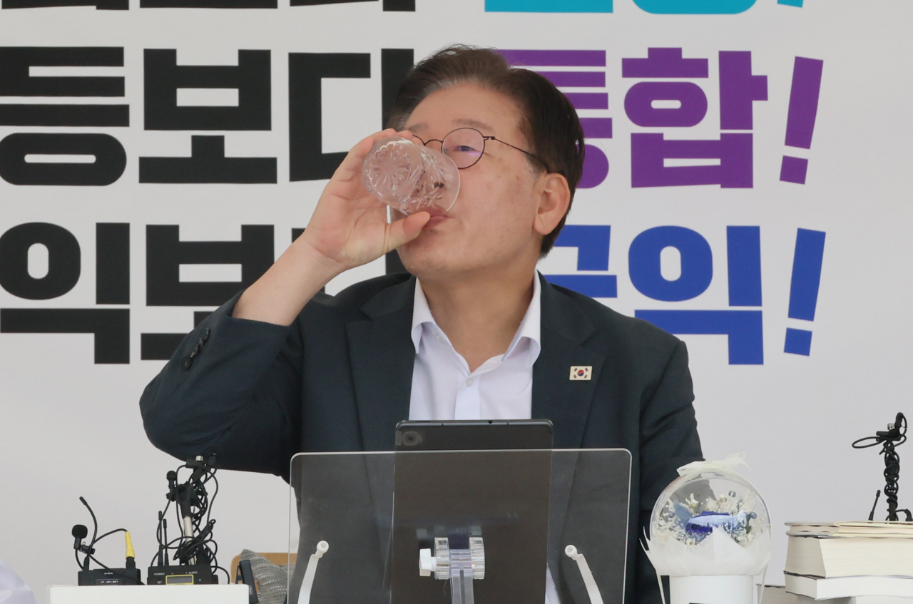 Democratic Party of Korea leader Rep. Lee Jae-myung is pictured drinking water as he continues his hunger strike for the fourth day on Sunday sitting inside a tent installed outside the National Assembly building. (Yonhap)