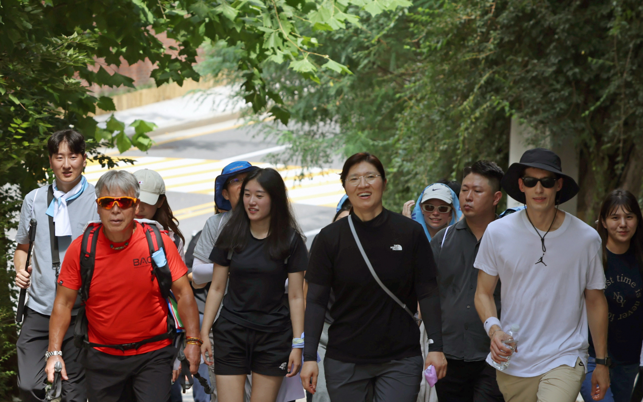 Mountaineer Um Hong-gil (front left), Second Vice Culture Minister Jang Mi-ran (front center) and TV personality Fabian Yoon (front right) hike together at the Culture Ministry’s special event on Tuesday, departing from Cheong Wa Dae to Bugaksan. (Culture Ministry)