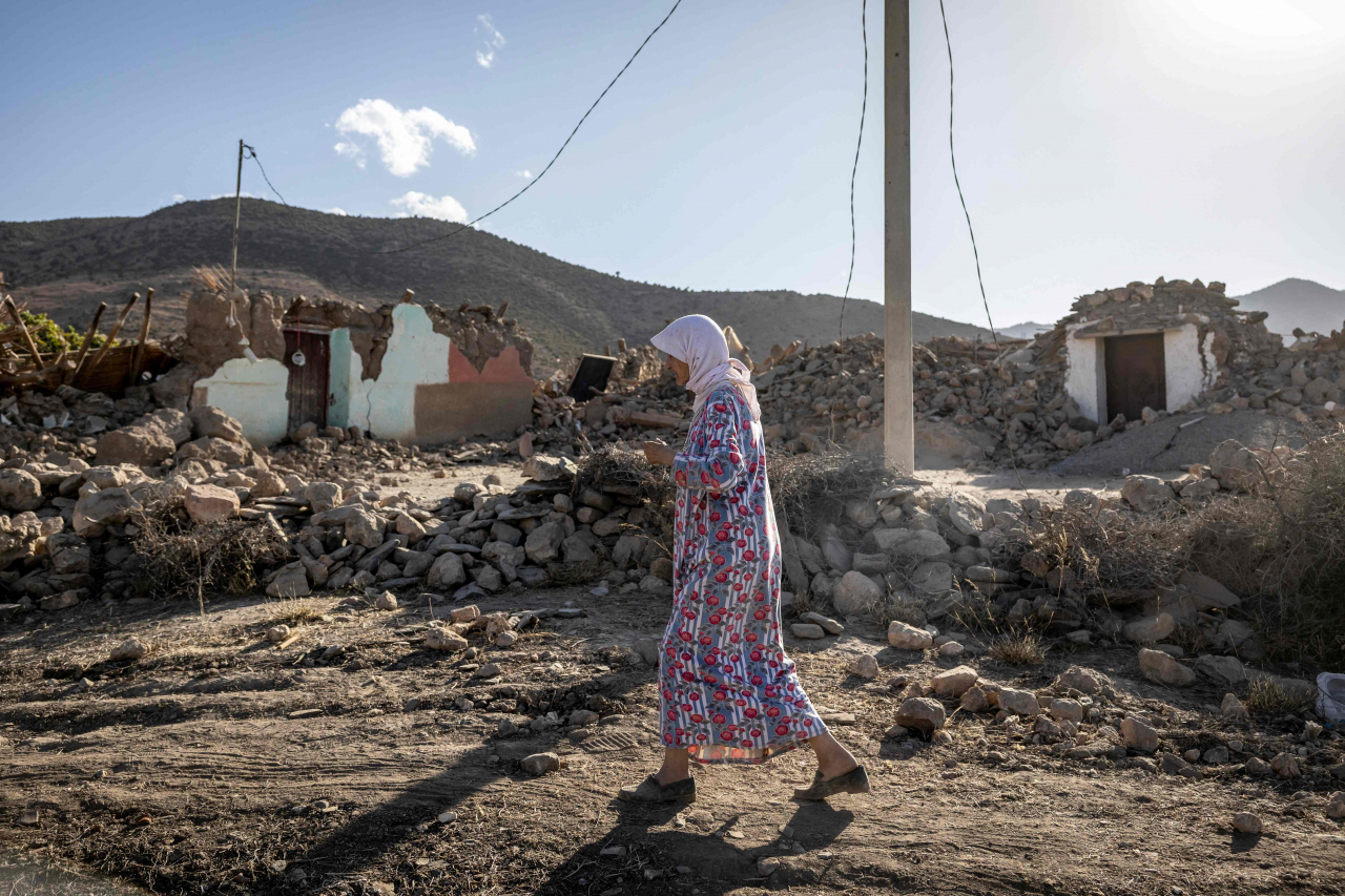 A woman walks past destroyed houses after an earthquake in the mountain village of Tafeghaghte, southwest of the city of Marrakesh, Sunday. (AFP-Yonhap)