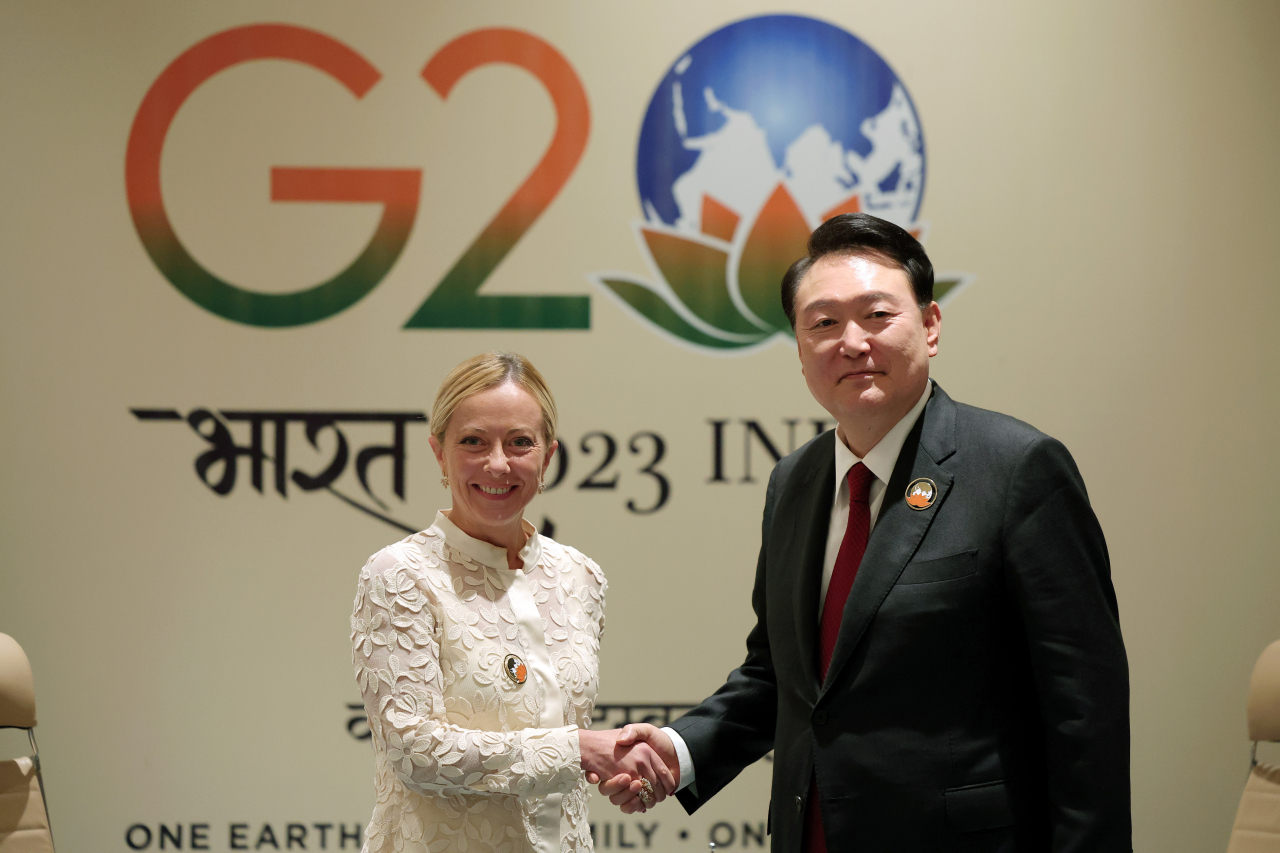 President Yoon Suk Yeol and Italian Prime Minister Giorgia Meloni shake hands during their meeting on the sidelines of the Group of 20 summit at the Bharat Mandapam convention center in New Delhi on Sunday. (Pool photo) (Yonhap)