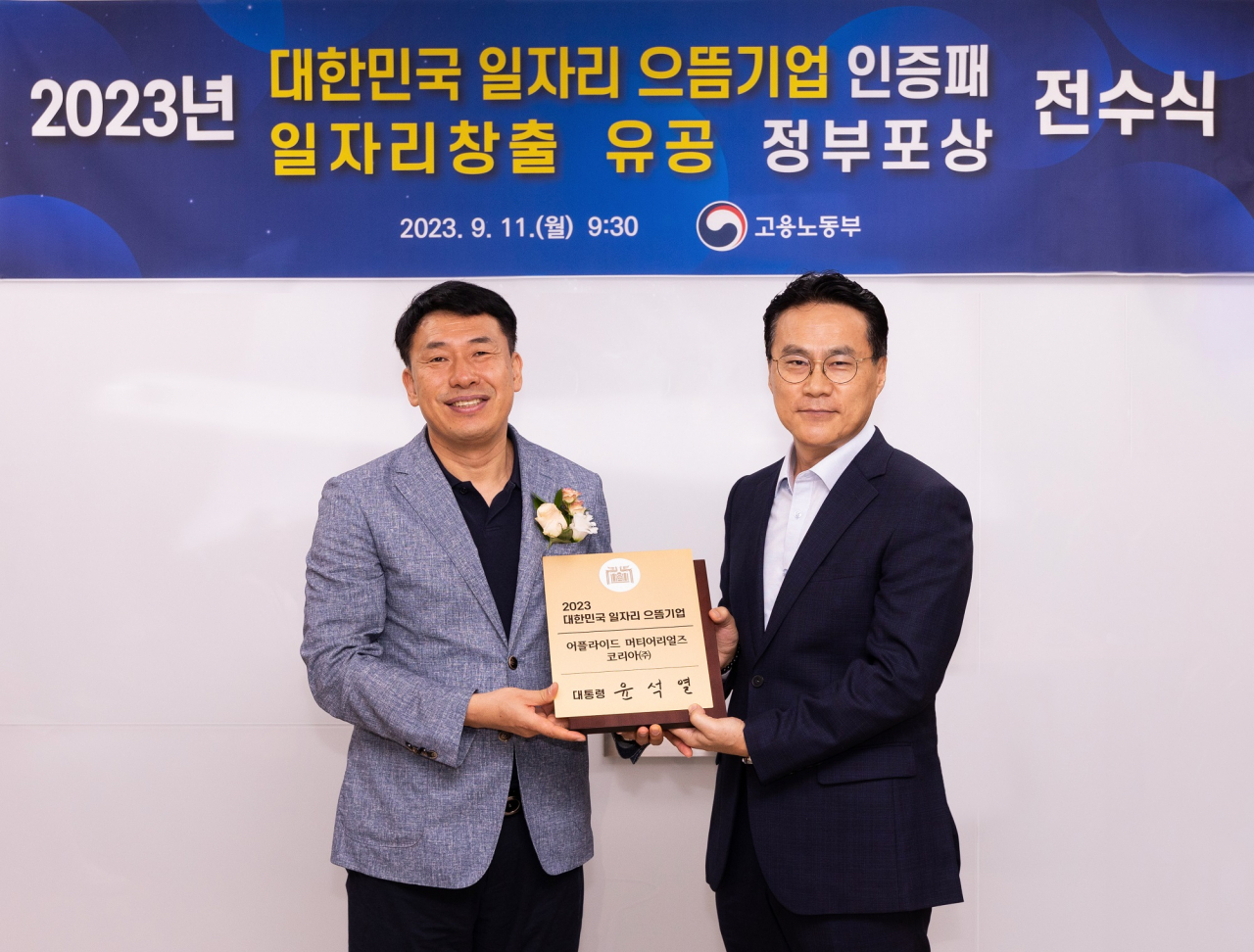 Yang Seung-chul, the head of Seongnam District Office of The Ministry of Employment and Labor, awards a recognition plaque to Park Bong-woo, HR director of Applied Materials Korea, during the Premier Employers Initiative ceremony held on Monday. (Applied Materials Korea)