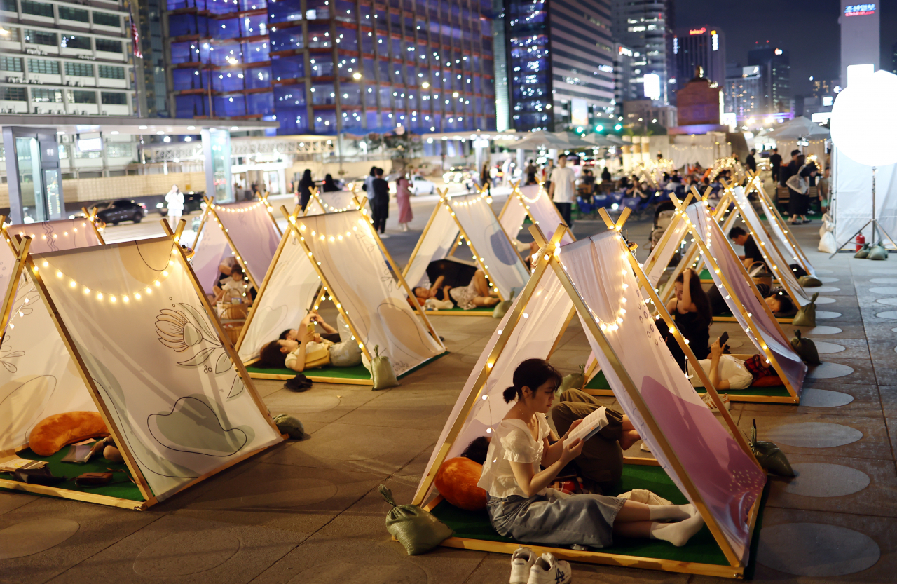 People read books at an outdoor library in Gwanghwamun Square, in Seoul, on Sept 3. (Yonhap)