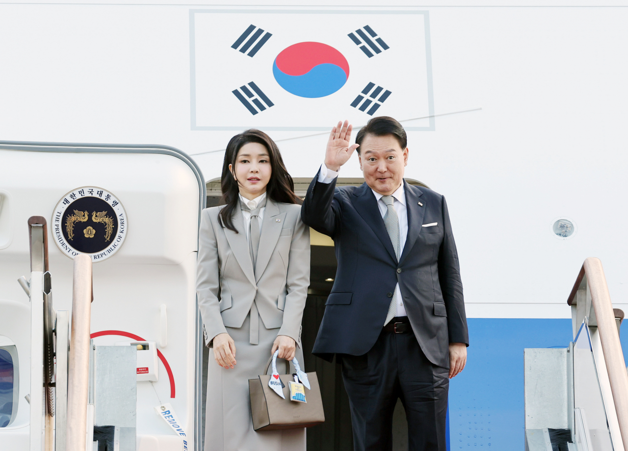 President Yoon Suk Yeol and first lady Kim Keon Hee pose for photos before boarding Air Force One at Seongnam Seoul Airport on Monday to depart for New York to attend the 78th United Nations General Assembly. (Yonhap)