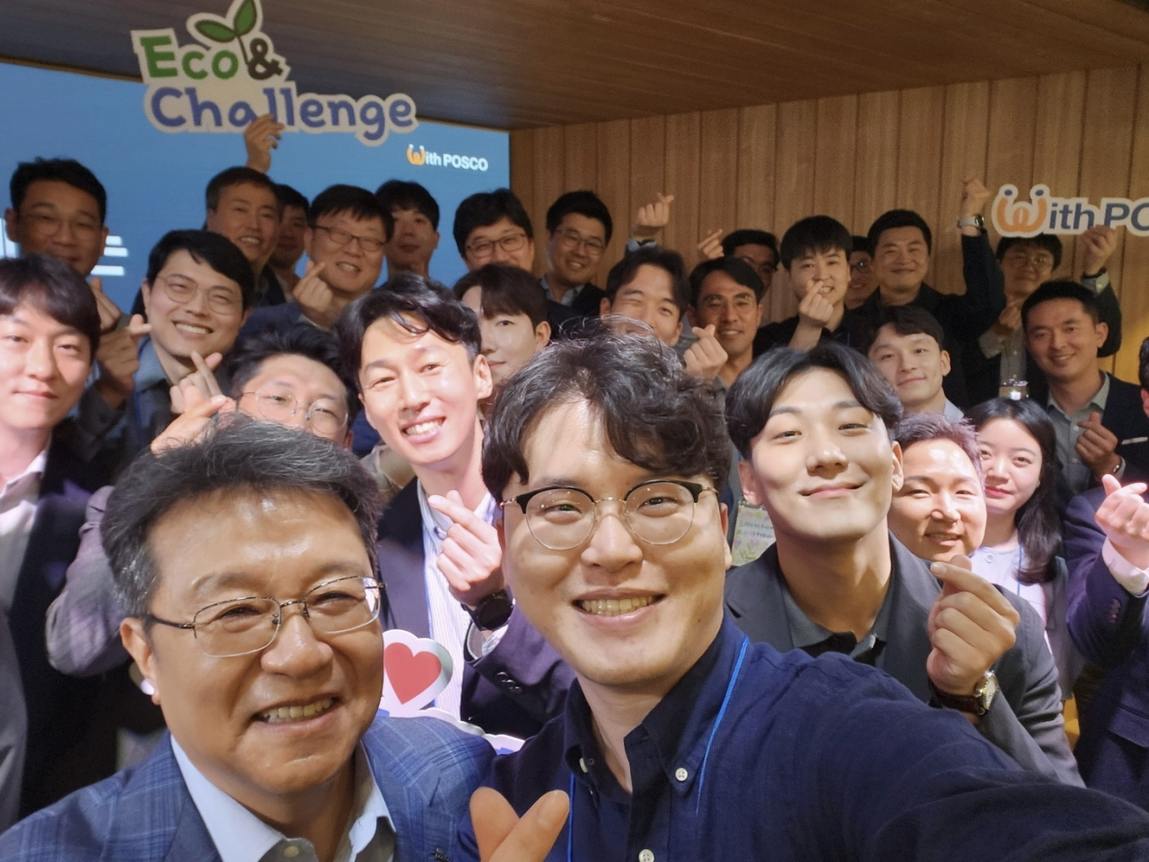 Posco E&C President Han Sung-hee (left) poses with employees for a group photo during a May company meeting where he shared the Eco & Challenge vision. (Posco Eco & Challenge)