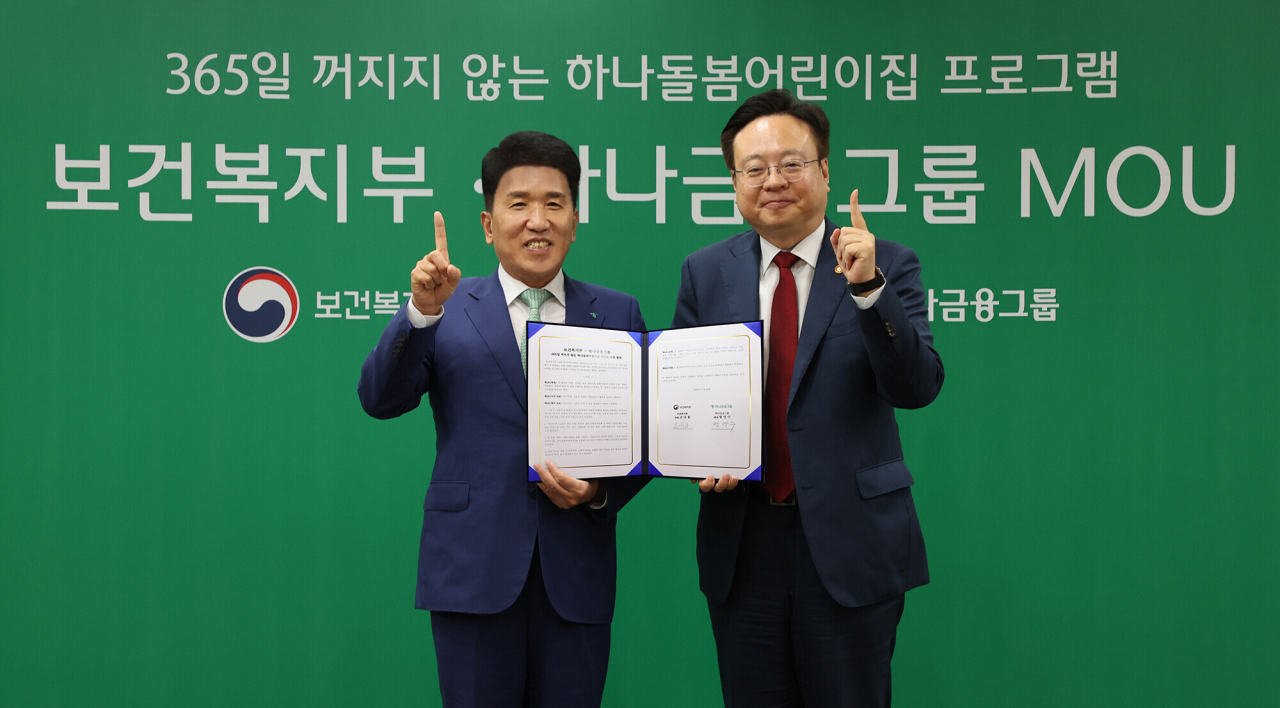 Hana Financial Group CEO Ham Young-joo (left) and Health and Welfare Minister Cho Kyoo-hong pose after the signing ceremony for the 