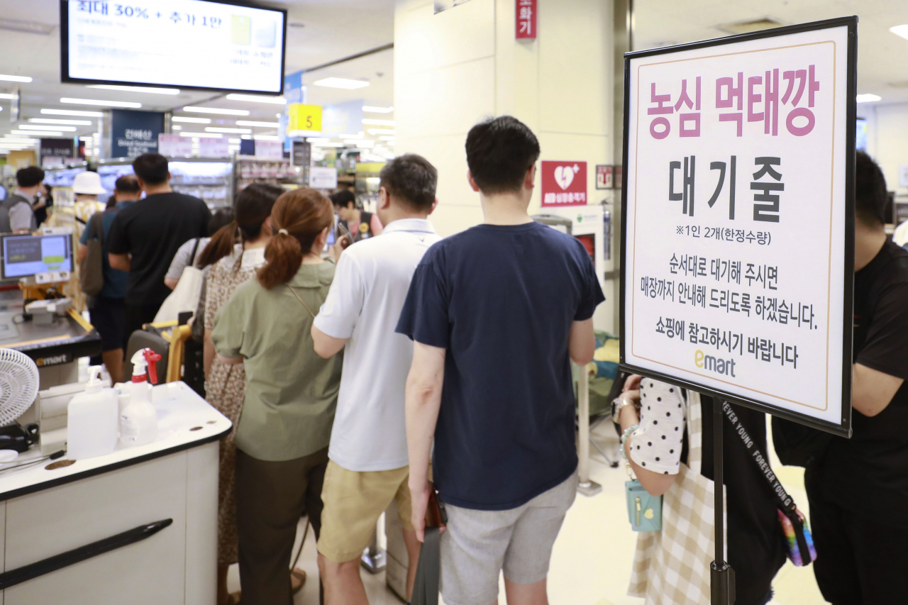 People wait in line to buy fish-flavored Meoktaekkang at an E-mart in Seoul, July 30. (Newsis)