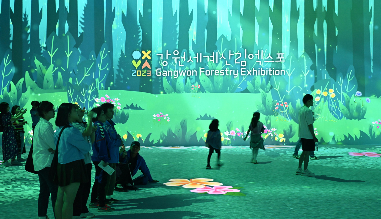 Visitors watch a video in the Green Earth Hall at the Gangwon Forestry Exhibition 2023 on Friday. (Lee Sang-sub/The Korea Herald)