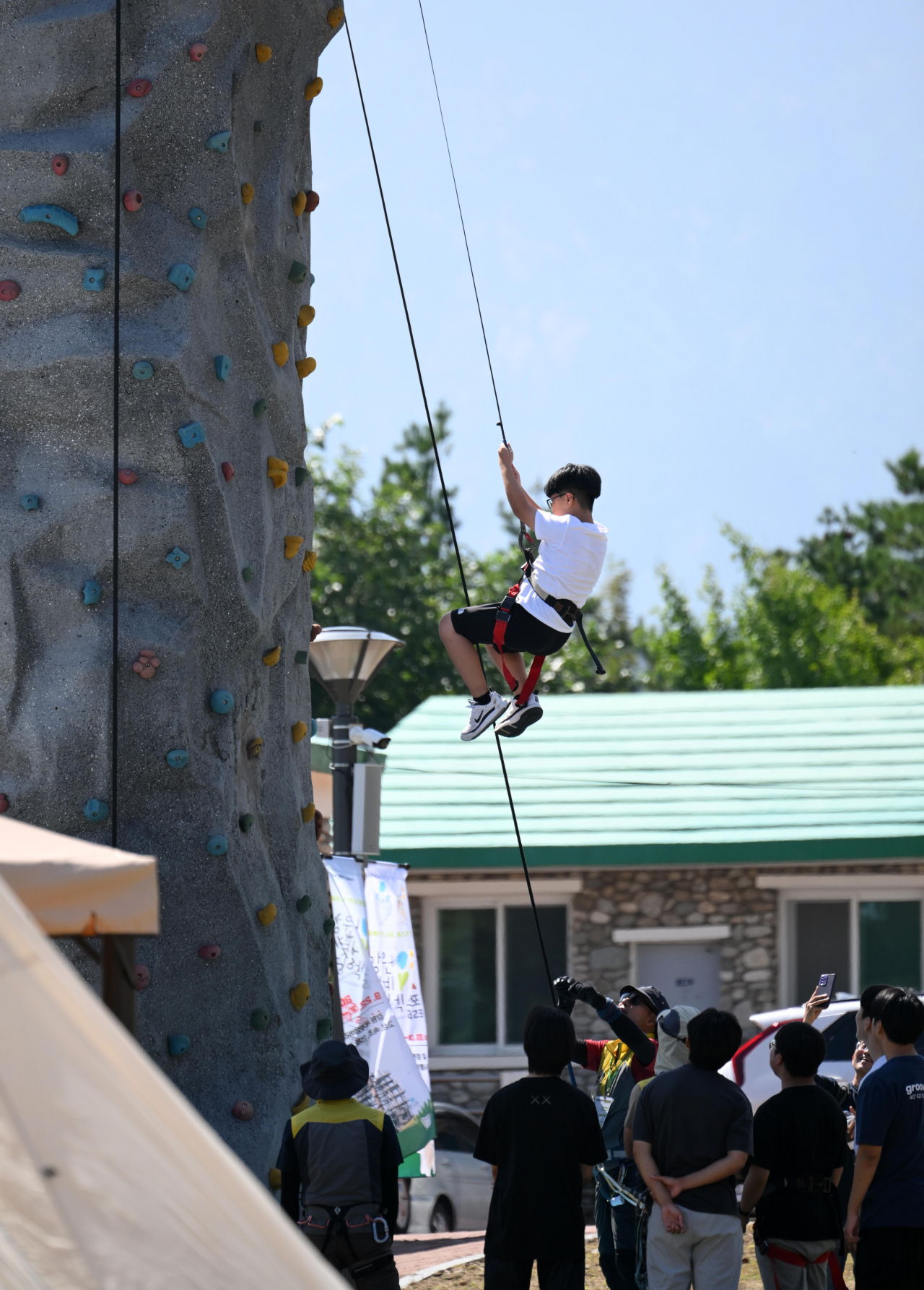 Children take part in a rock climbing experience at the Gangwon Forestry Exhibition 2023 in Goseong, Gangwon Province on Friday. (Lee Sang-sub/The Korea Herald)