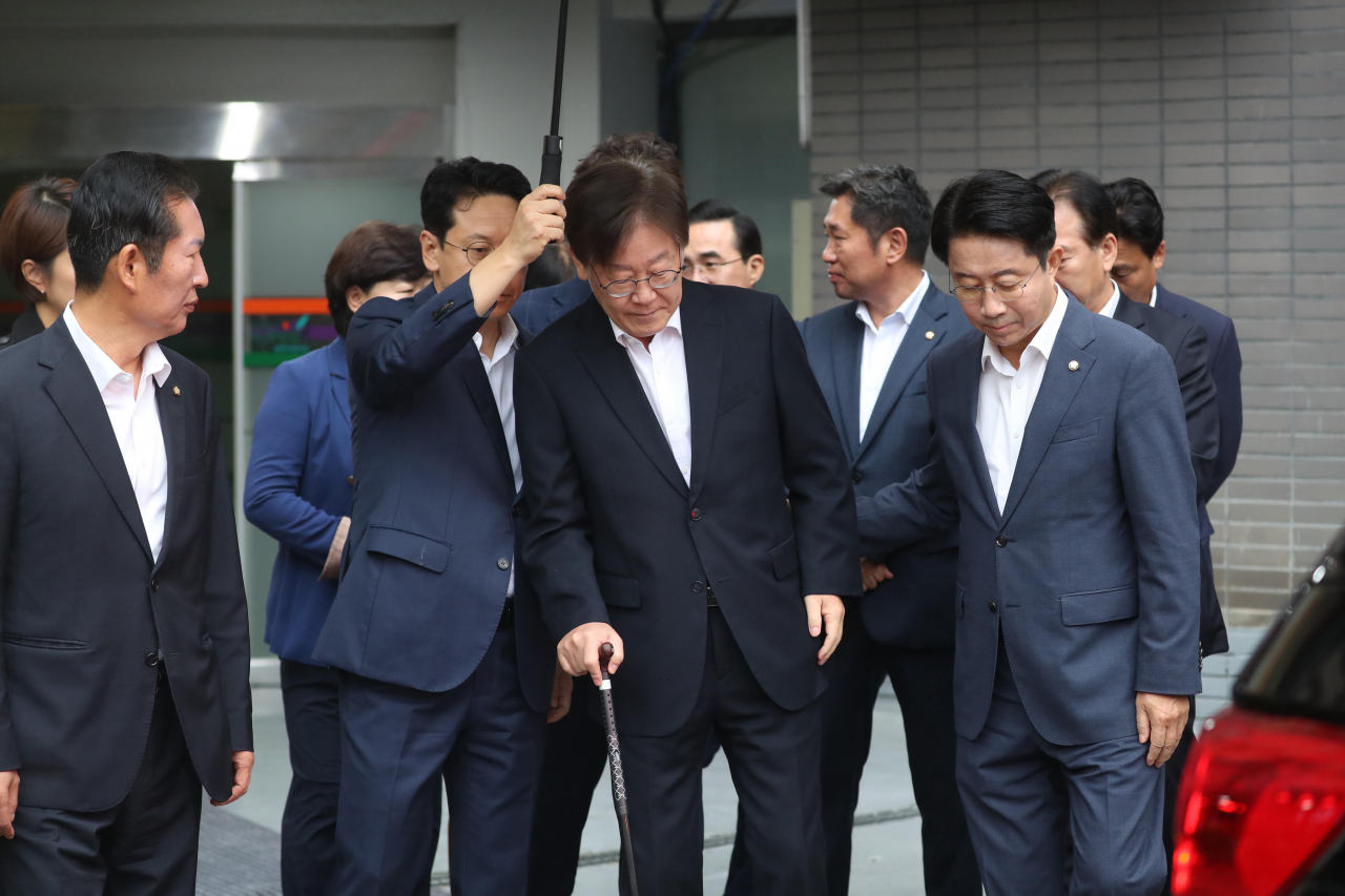 Surrounded by party members, Lee Jae-myung, chair of the Democratic Party, leaves a hospital in Seoul to attend a hearing for an arrest warrant on Tuesday at the Seoul Central District Court. (Yonhap)