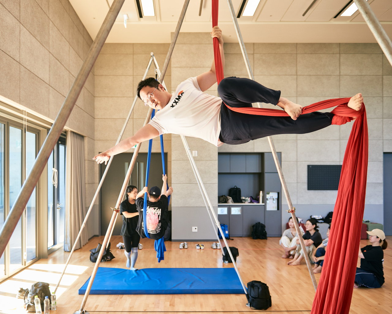 Participants try out aerial silk performing during a 