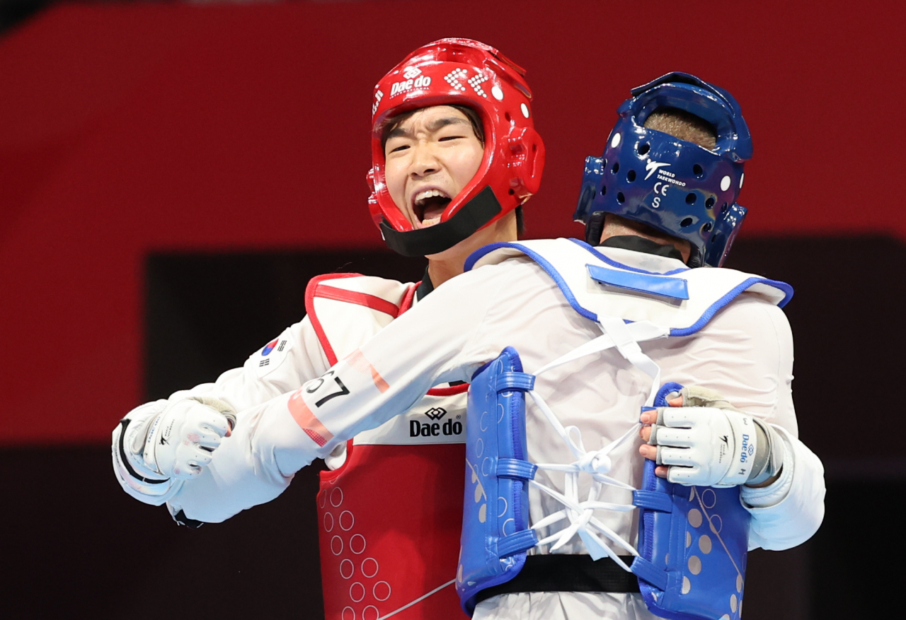 South Korea's Park Woo-hyeok (left) celebrates his victory in the final of the men's -80kg taekwondo competition at Lin'an Sports Culture & Exhibition Centre in Hangzhou, China, during the 19th Asian Games. (Yonhap)