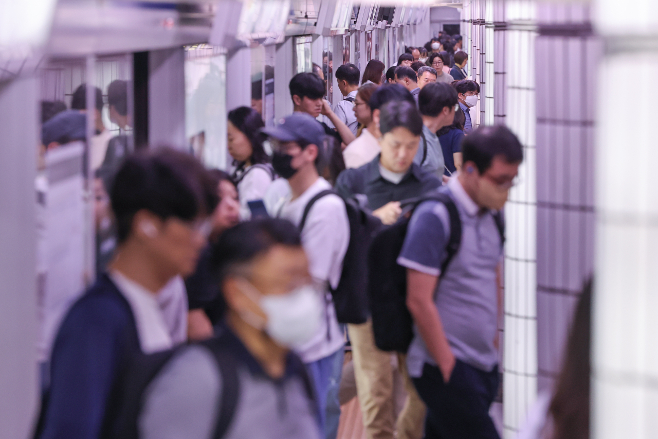 Passengers walk along an underground platform of City Hall Subway Station in central Seoul in September. (Yonhap)