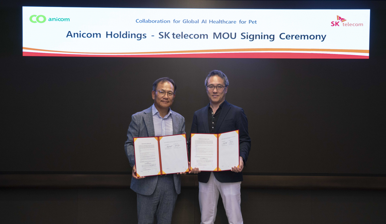 Chief Development Officer of SK Telecom Ha Min-yong (left) and Anicom Holdings CEO Komori Nobuaki pose for a photo after singing a memorandum of understanding on artificial intelligence-based health care services for pets at SK Telecom's headquarters in Seoul, Sept. 20. (SK Telecom)