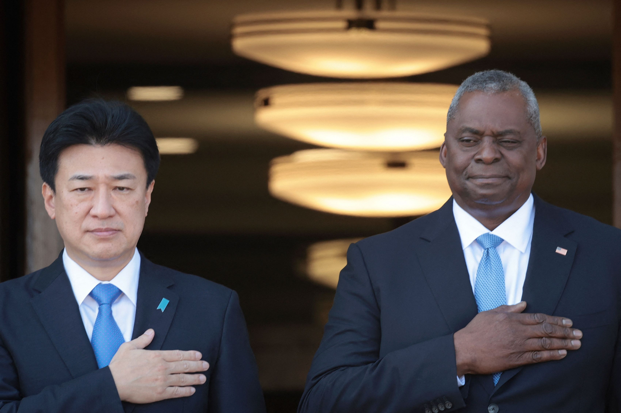 US Secretary of Defense Lloyd Austin (right) and Japanese Defense Minister Minoru Kihara (left) place their hands over their hearts during an honor cordon ceremony and the playing of the national anthem at the Pentagon on Thursday in Arlington, Virginia. (AFP-Yonhap)