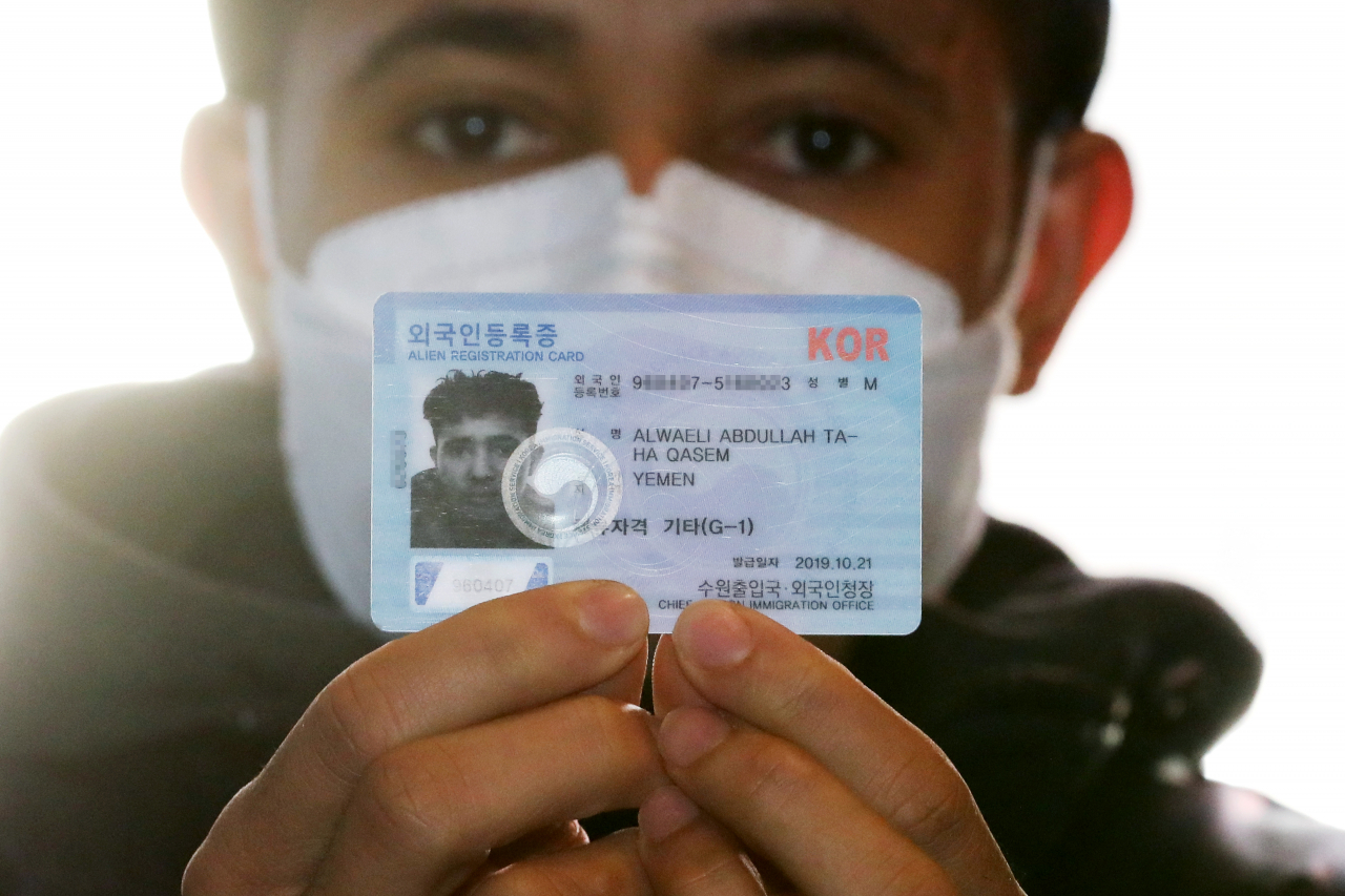 A foreign resident presents his alien registration card. (Newsis)