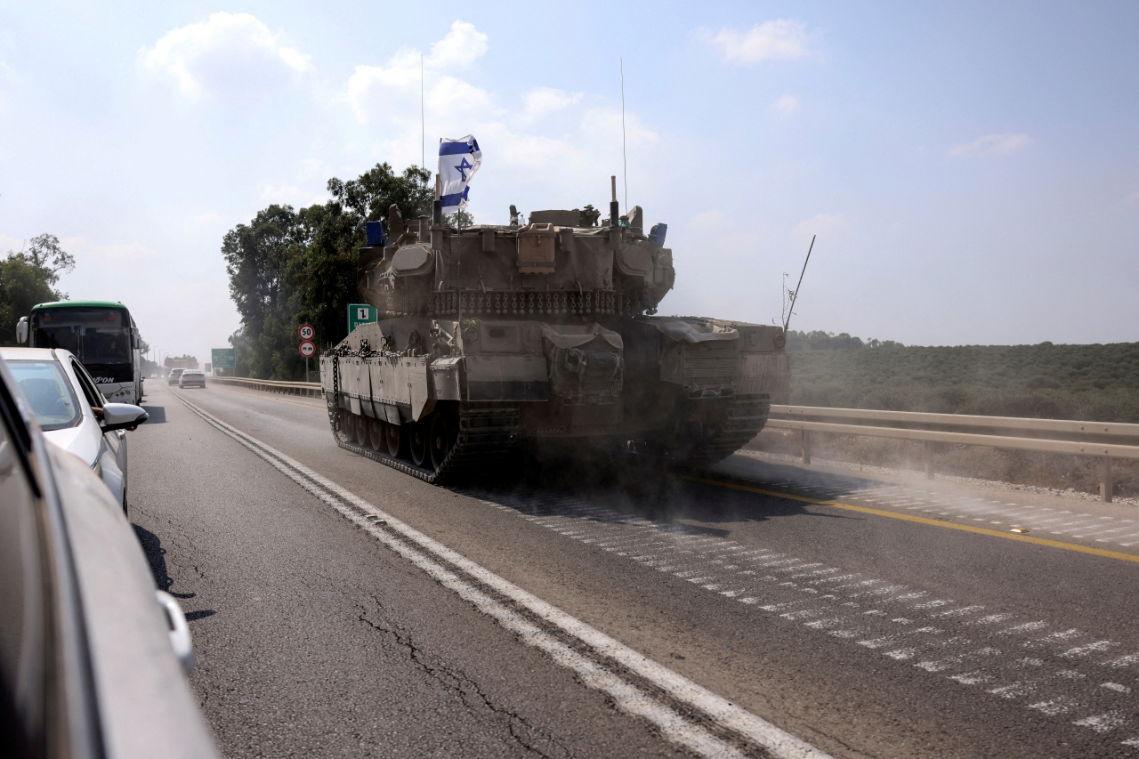 An Israeli tank drives on a road following a mass infiltration by Hamas gunmen from the Gaza Strip, near Sderot in southern Israel Sunday. (Reuters-Yonhap)
