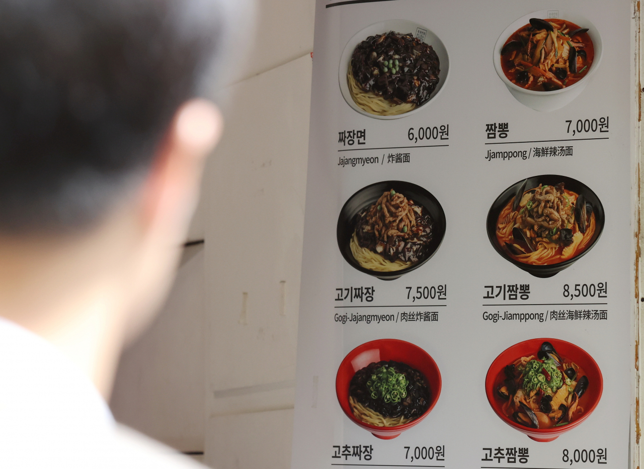 A person looks at a restaurant menu in Jung-gu, central Seoul. (Yonhap)