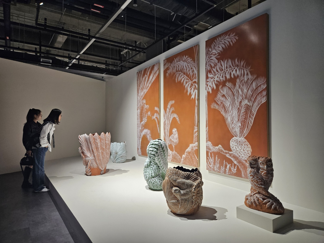 Visitors take a closer look at ceramic artist Kim Myung-jin's terracotta works on Thursday at Culture Factory in Cheongju. (Park Yuna/The Korea Herald)