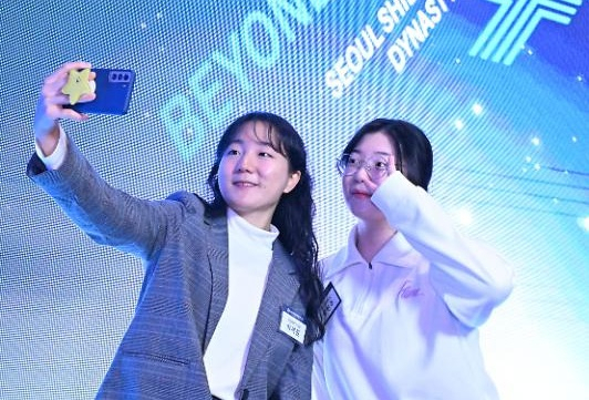 Two students take photographs of themselves at the HIT Forum, held at the Shilla Seoul, Wednesday. (Im Se-jun/The Korea Herald).