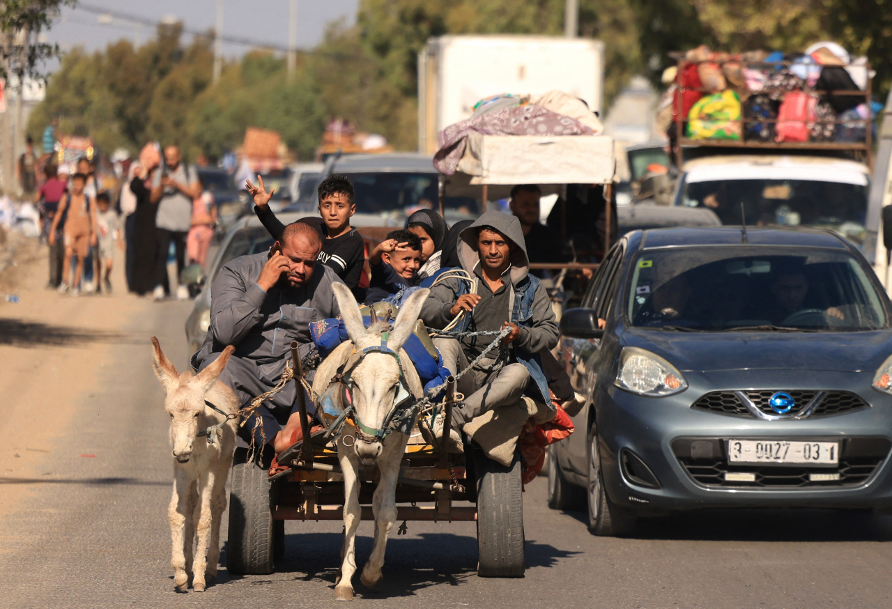 Riding a donkey drawn cart as family along with hundreds of other Palestinian carrying their belongings flee following the Israeli army's warning to leave their homes and move south before an expected ground offensive, in Gaza City on Friday. (AFP-Yonhap)