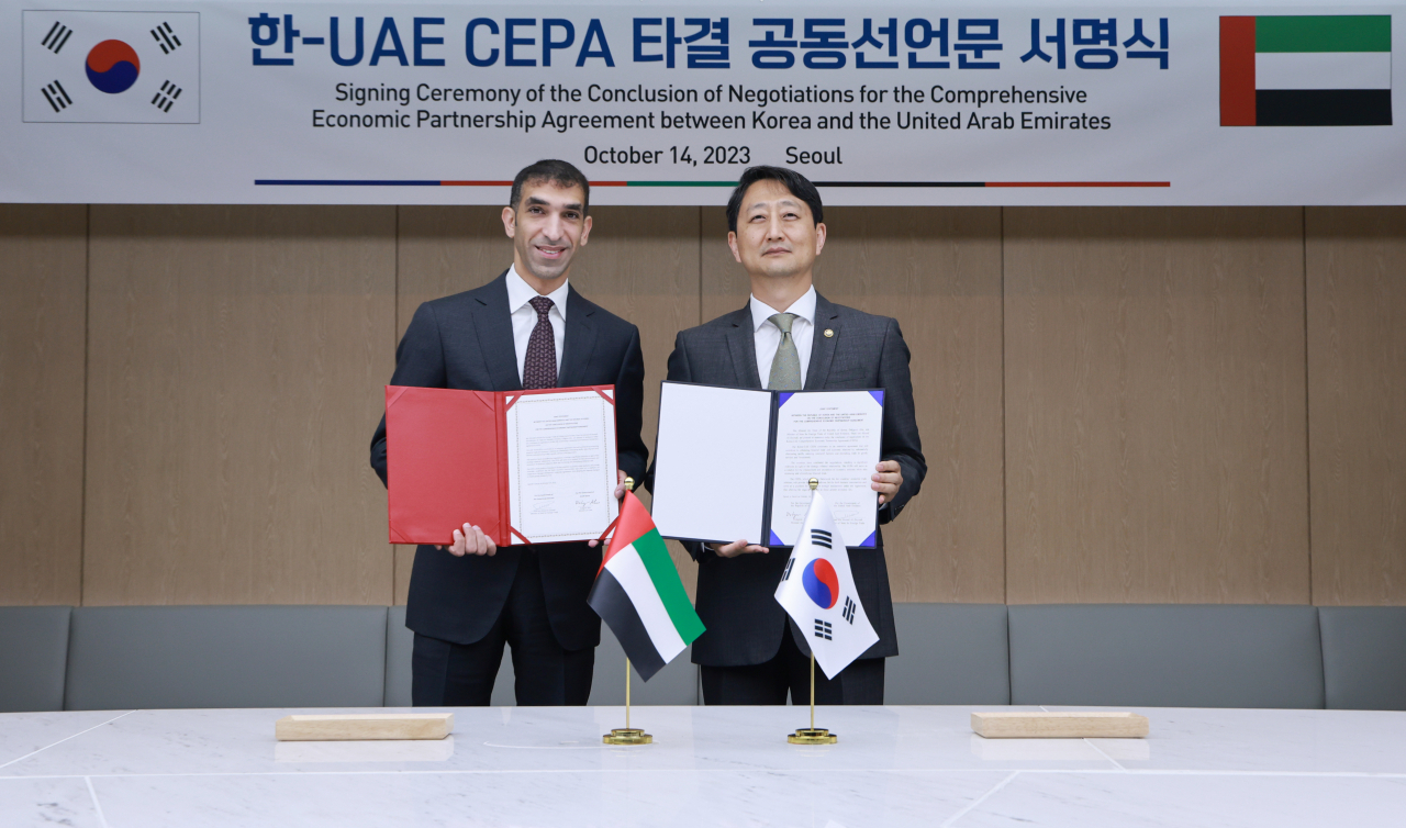 South Korea's Trade Minister Ahn Duk-geun (right) and the UAE's foreign trade minister, Thani bin Ahmed Al Zeyoudi, pose for picture after signing a joint statement on the conclusion of negotiations for the bilateral Comprehensive Economic Partnership Agreement at the Korea Chamber of Commerce and Industry building in Seoul on Saturday. (Yonhap)