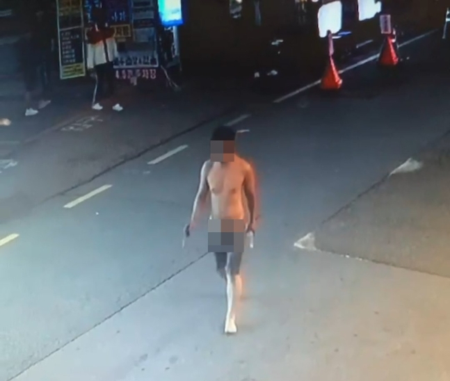A drunk, undressed man carrying scissors and a bottle of soju in Suwon, Gyeonggi Province. (Courtesy of reader)