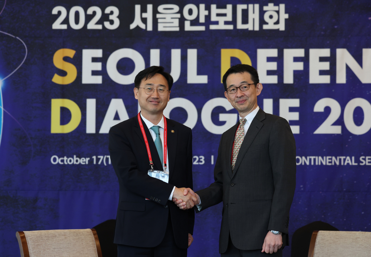 South Korea's Vice Defense Minister Shin Beom-chul (left) and Japanese Vice Minister of Defense for International Affairs Kiyoshi Serizawa hold hands during the bilateral talks held on Wednesday on the sidelines of Seoul Defense Dialogue 2023. (Ministry of National Defense)