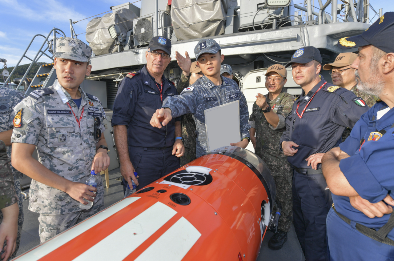 Naval officials from South Korea and others take part in a briefing on a mine disposal vehicle aboard a naval ship on Wednesday, ahead of a multinational anti-mine exercise in waters southeast of the southern island of Geoje, 330 kilometers southeast of Seoul, in this photo provided by South Korea's Navy. (Yonhap)