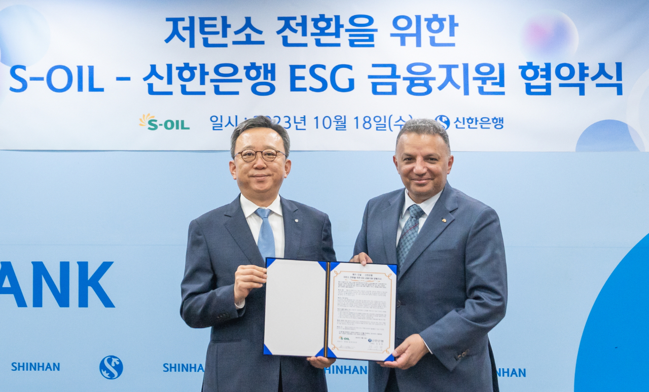 S-Oil CEO Anwar al-Hejazi (right) and Shinhan Bank CEO Jung Sang-hyuk pose for a photo after signing a memorandum of understanding for ESG financial support at Shinhan Bank headquarters in Seoul on Wednesday. (S-Oil)