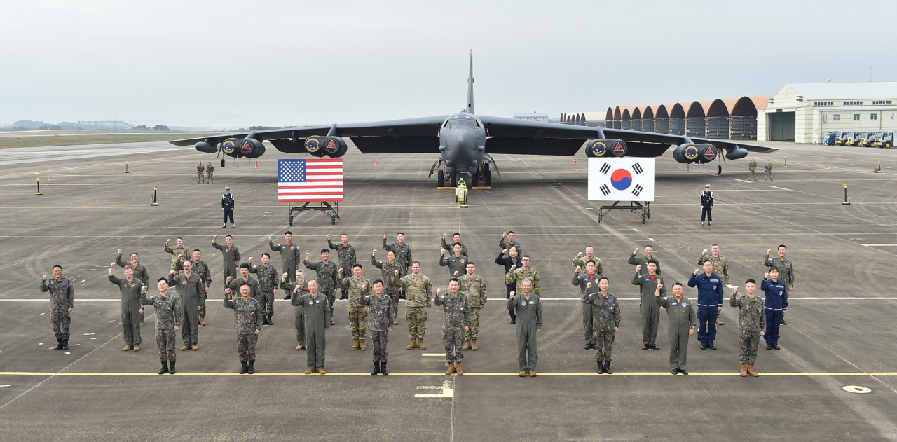 Chairman of the Joint Chiefs of Staff Kim Seung-kyum (center, front row), South Korean Air Force Chief of Staff Gen. Jung Sang-hwa (fourth from left, front row) and US Pacific Air Forces Commander Kenneth Wilsbach (fourth from right, front row) pose for a photo in front of the nuclear-capable US strategic bomber B-52H that landed in Korea for the first time, at the Air Force base in Cheongju, North Chungcheong Province, Thursday. (Joint Chiefs of Staff)