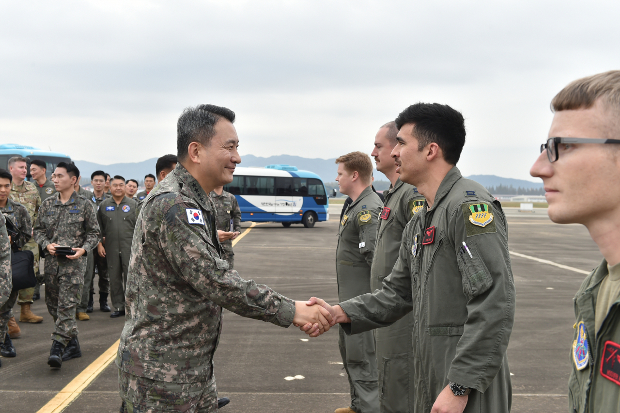 South Korea's Joint Chiefs of Staff Chairman Gen. Kim Seung-kyum (left) encourages operational officers of a US B-52H strategic bomber at a South Korean combat squadron on Thursday. (Joint Chiefs of Staff)