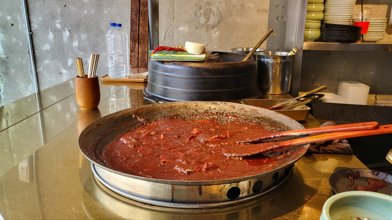 Tteokbokki is cooked in a large pot at Tteoksan. (Kim Hae-yeon/ The Korea Herald)