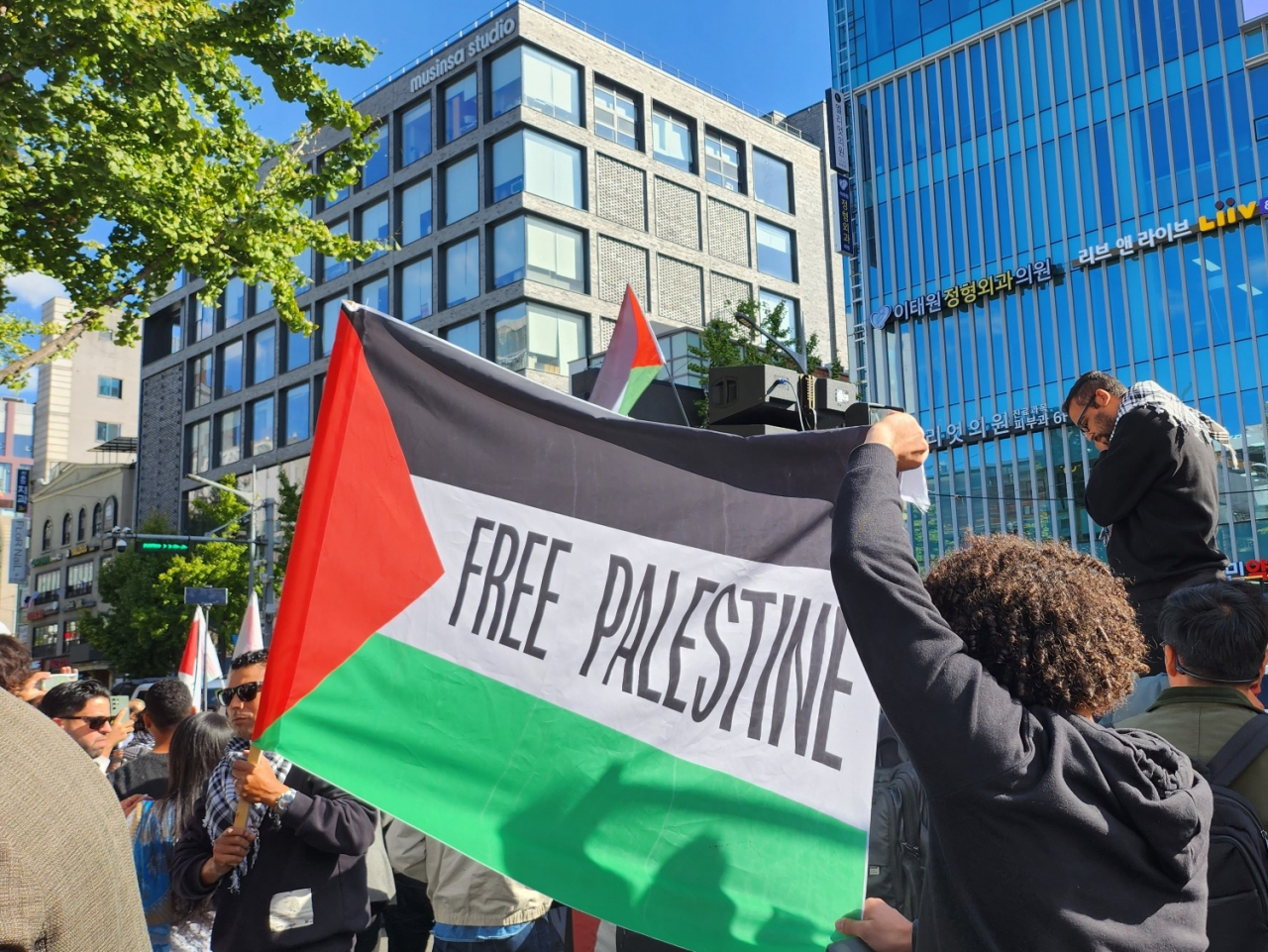 Demonstrators hold the national flag of Palestine during the rally supporting the Palestine resistance, organized by leftist civic group Workers' Solidarity and local Muslim group Kore de Islam, Friday, near Itaewon Station Seoul Subway Line. No.6. (Lee Jung-youn/The Korea Herald)