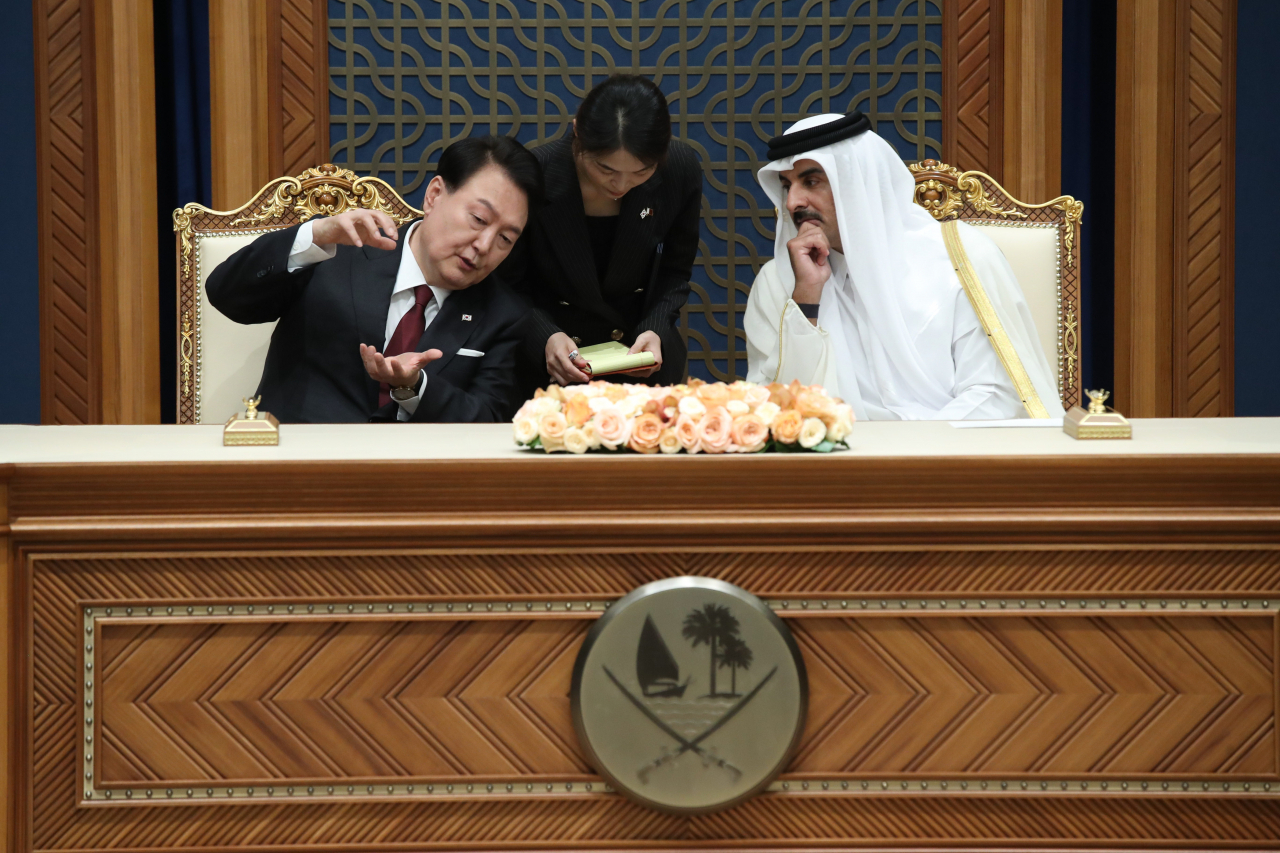 President Yoon Suk Yeol (left), who is on a state visit to Qatar, talks with Qatar's Emir Sheikh Tamim bin Hamad Al Thani at the Korea-Qatar memorandum of understanding signing ceremony held at Amiri Diwan, the royal palace of Qatar, in Doha on Wednesday.