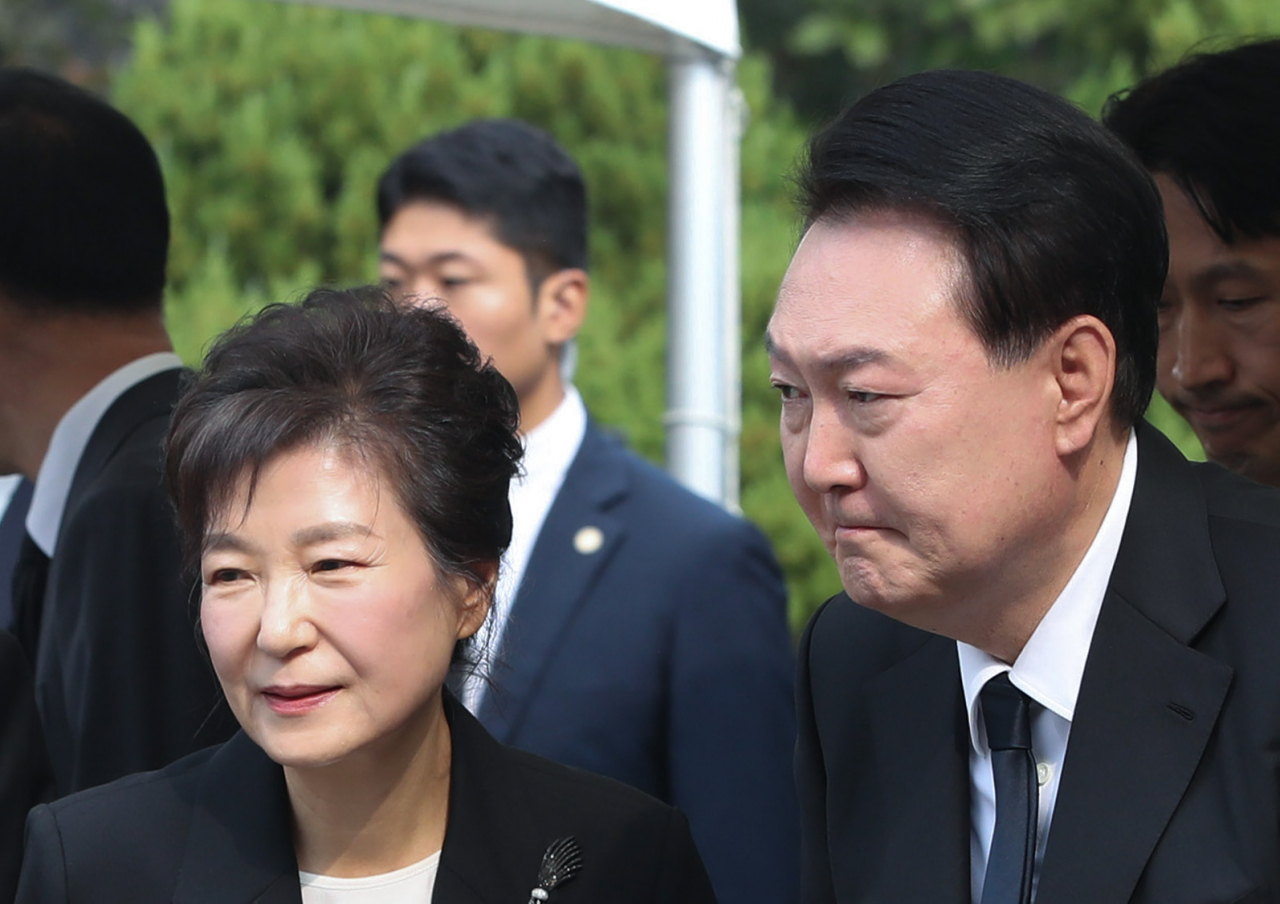 President Yoon Suk Yeol (right) are seen with ex-president Park Geun-hye during a death anniversary of Park's father and ex-president, Park Chung-hee, held at the Seoul National Cemetery Thursday. (Yonhap)
